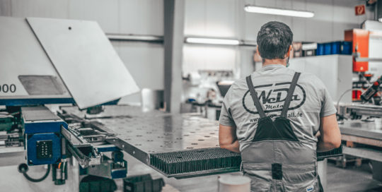 Mann an Metallstanzmaschine