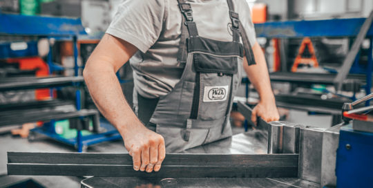 Mann richtet Metall auf Werkbank aus