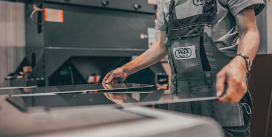 Mann steht an Metallmaschine