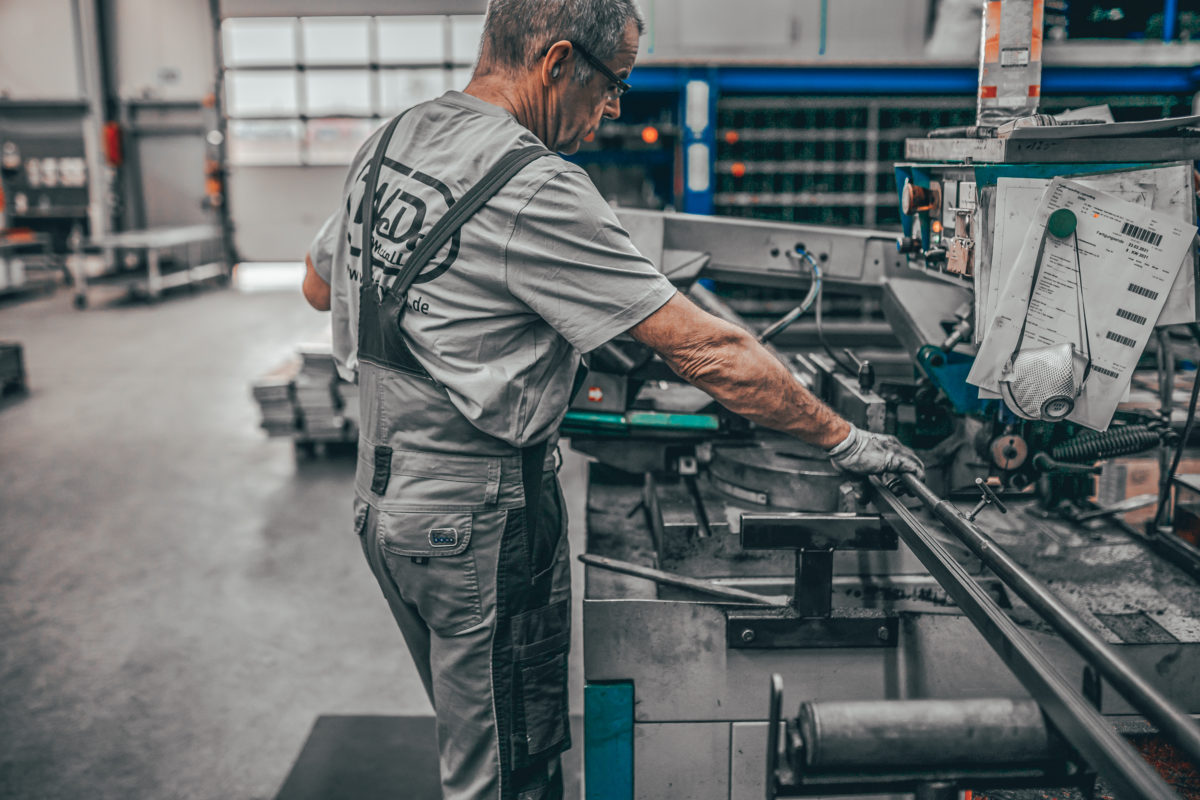 Mitarbeiter von Weda-Metall bedient Metallschneidemaschine