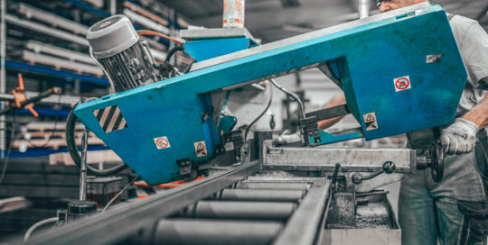 Mitarbeiter von Weda-Metall bedient Metallschneidemaschine