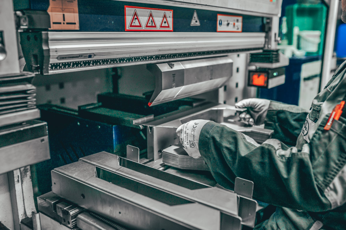 Mitarbeiter von Weda-Metall legt Metall in eine Maschine